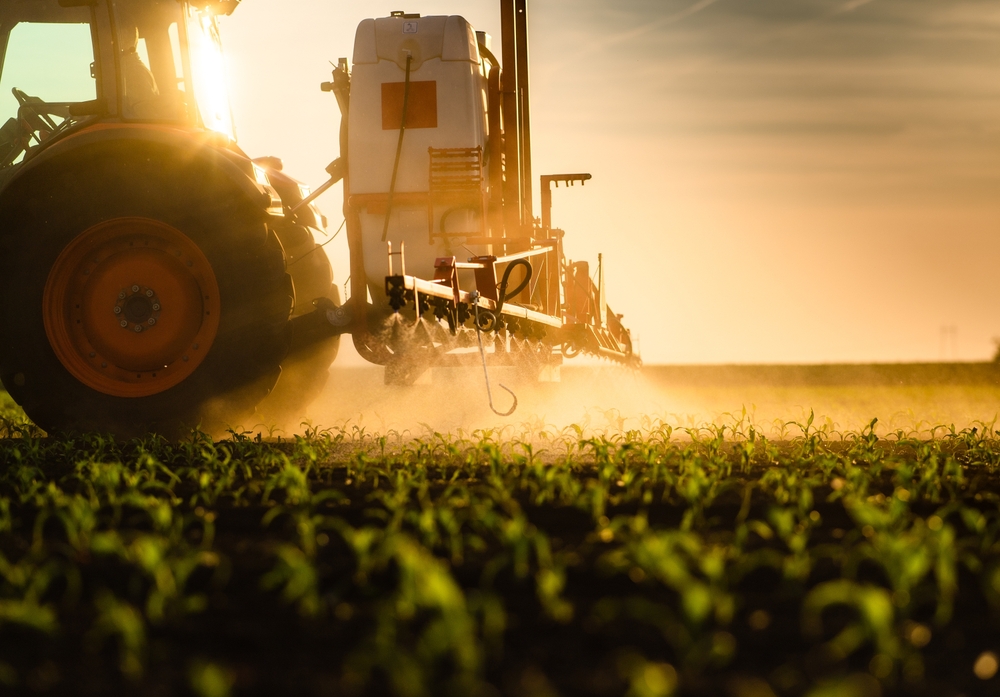 Tractor sprayer executing a fertility program at golden hour